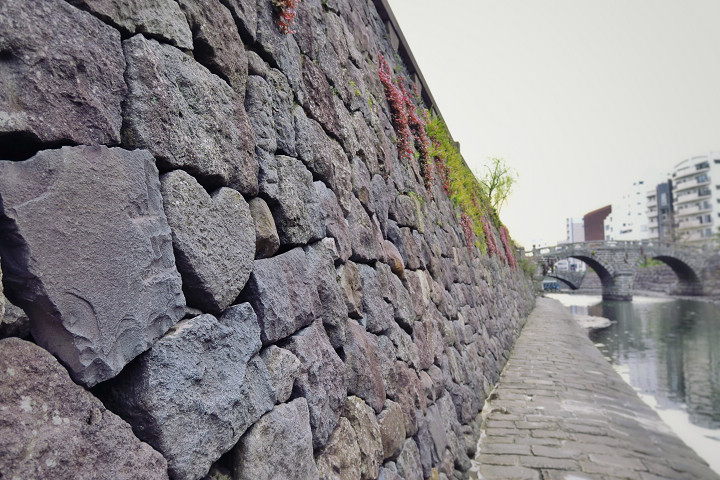 眼鏡橋兩旁的河堤上藏有許多顆愛心石。　圖：長崎縣觀光連盟／提供